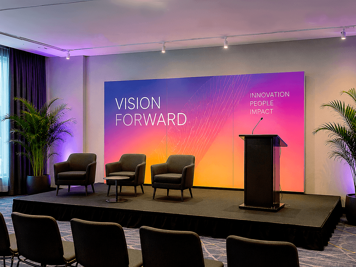 Forex conference stage backdrop with gradient print, podium, and panel seating under spotlights