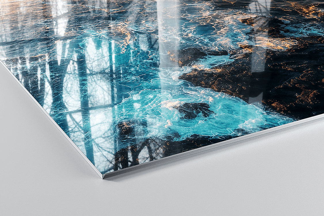 ChromaLuxe Glossy aluminium panel with turquoise coastal seascape and dark rocks, showing the highly reflective mirror-like surface finish
