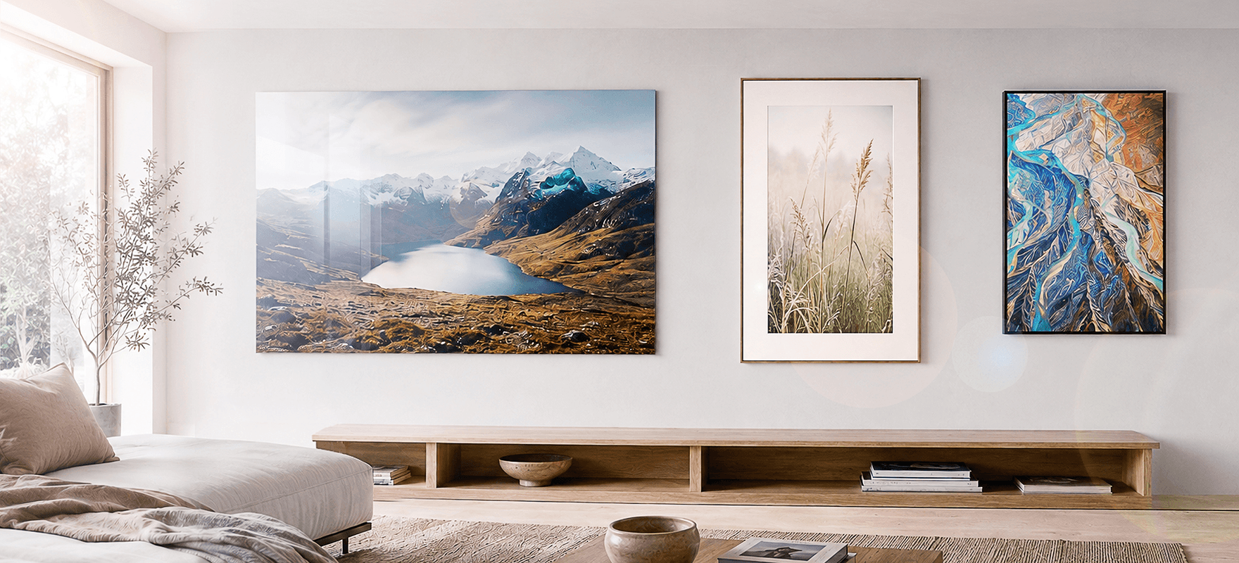 Three photo prints in a modern living room: acrylic mountain landscape, framed botanical, and abstract river aerial