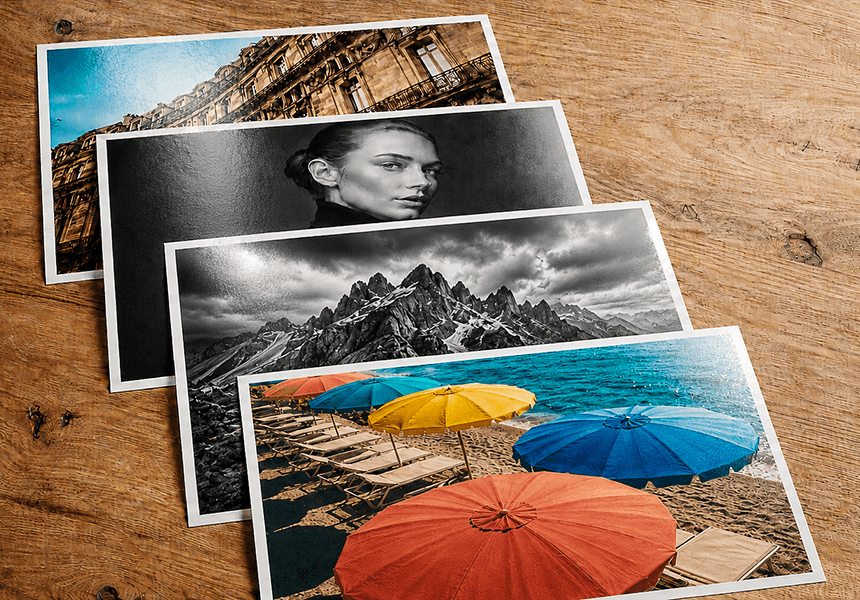 Four baryta prints showing architecture, black-and-white portrait, dramatic mountain peaks and colourful beach umbrellas