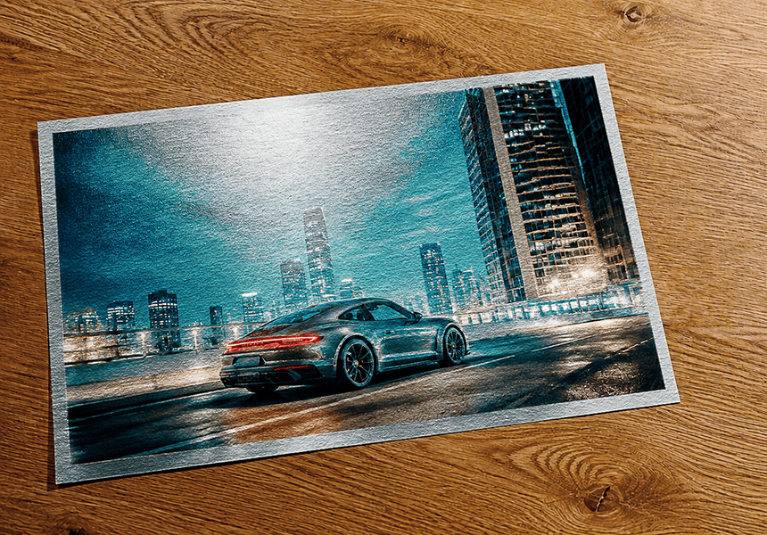 Metallic print of a sports car on wet city street at night with illuminated skyscrapers showing pearlescent surface effect