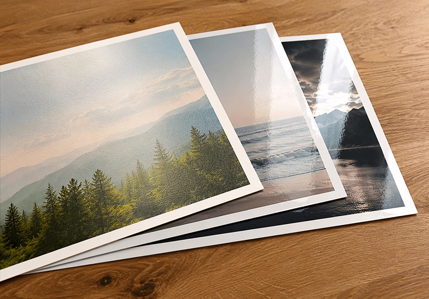 Three durable photo paper prints on wood showing forest landscape, ocean waves and dramatic sunset with mountain silhouette