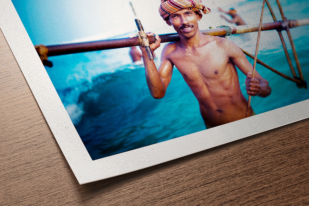Fine art print on Hahnemühle Photo Rag 308 showing a fisherman with colourful turban against turquoise water, soft matte cotton paper texture