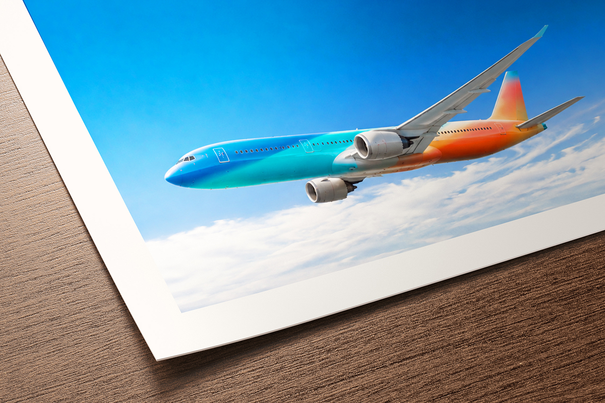 Fine art print on Canson Rag Photographique II showing colourful aircraft flying through blue sky above clouds, smooth matte cotton surface