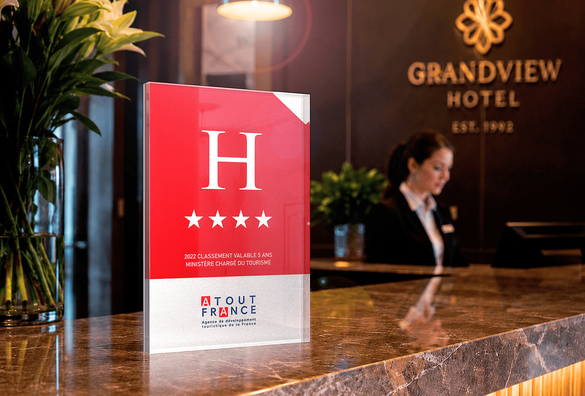 Acrylux Block displaying 4-star hotel classification plaque on marble reception desk with receptionist in background