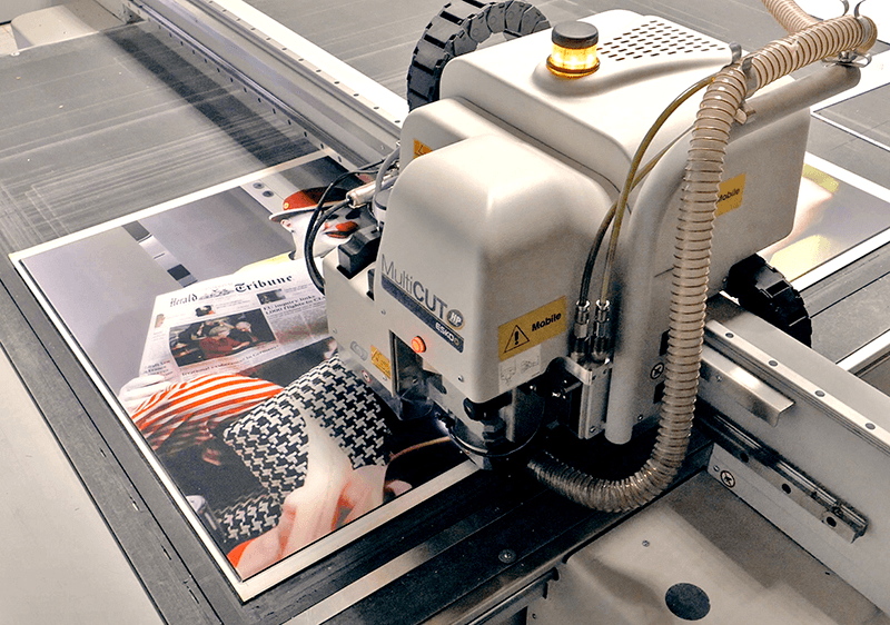 CNC cutting machine precisely trimming printed panels in the AuthenticPhoto workshop