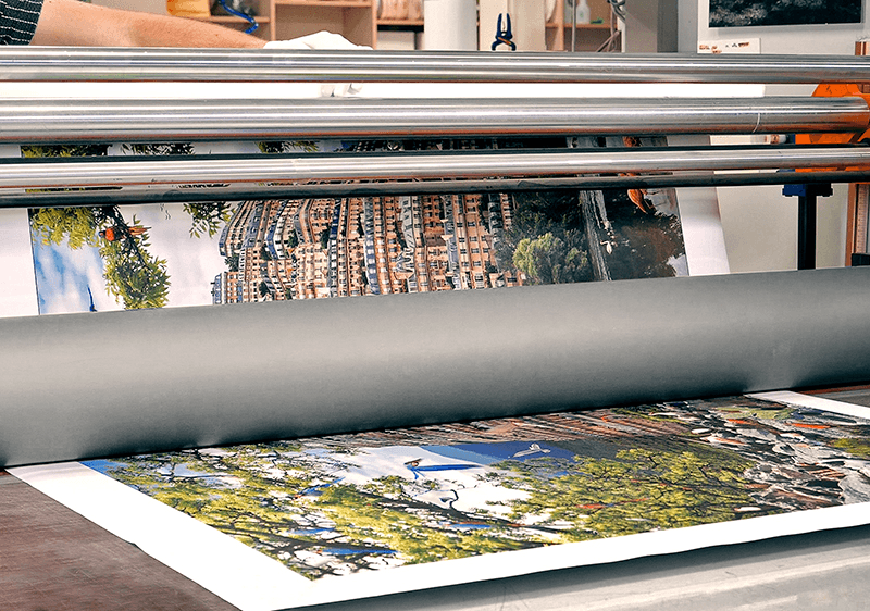 Large-format laminator bonding a printed photo onto a rigid mounting board