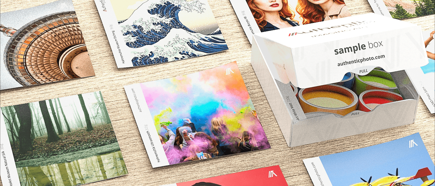 Fine art photo print sample set with branded box and colourful printed samples on a wooden surface