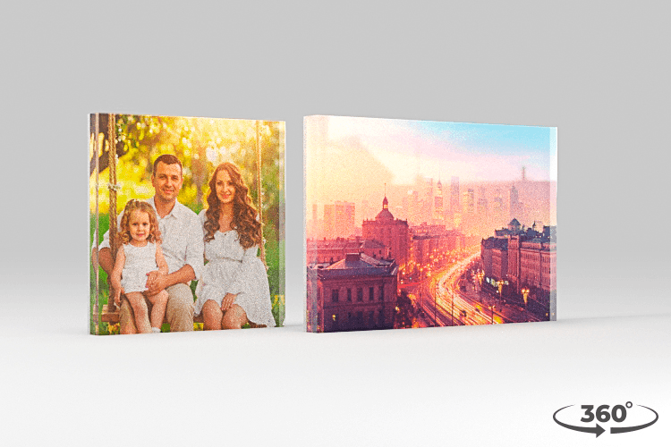 Two Acrylux Block photo prints showing a family portrait and city skyline, displayed as freestanding acrylic objects